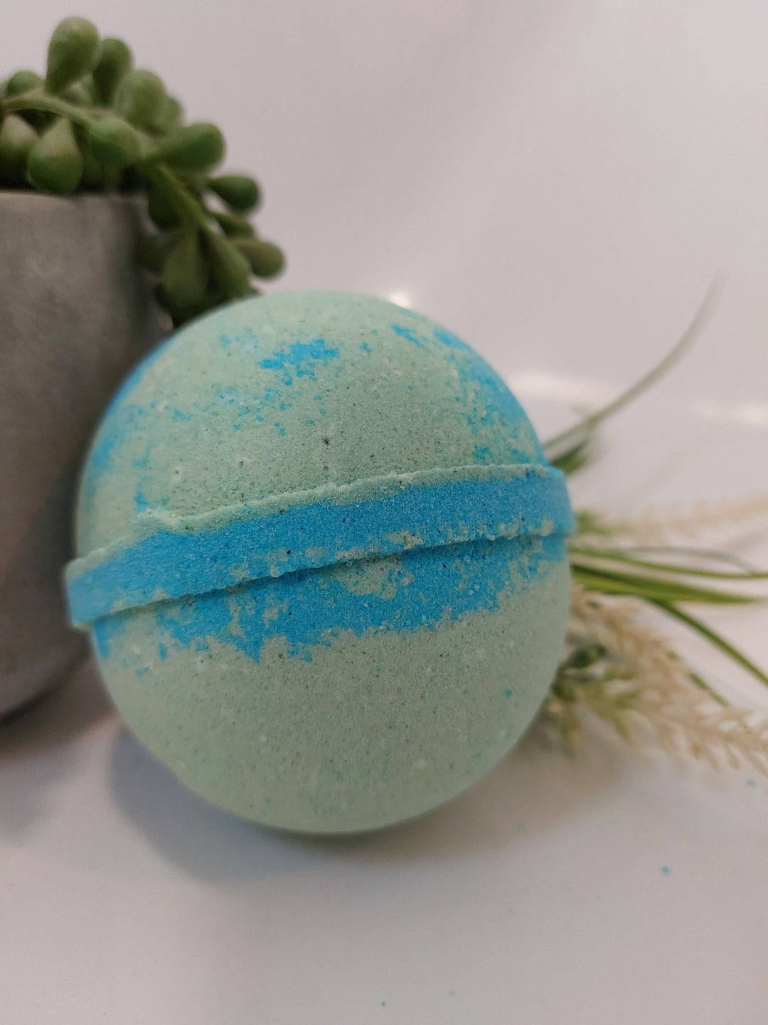A large bath bomb with a blue and green color scheme, in adventurous fragrance by BubbleShop
