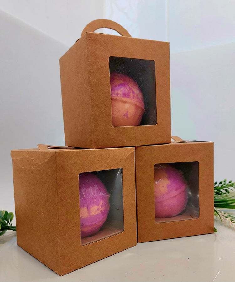 3 gift boxes with bath bombs in side in the colours of pink and orange fantasy perfume inspired