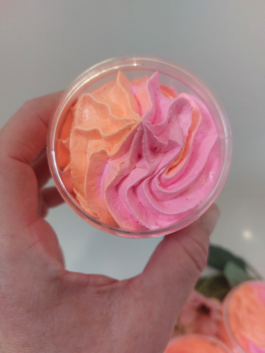 top view of pink and orange piped whipped soap in hand in fantasy by BubbleShop