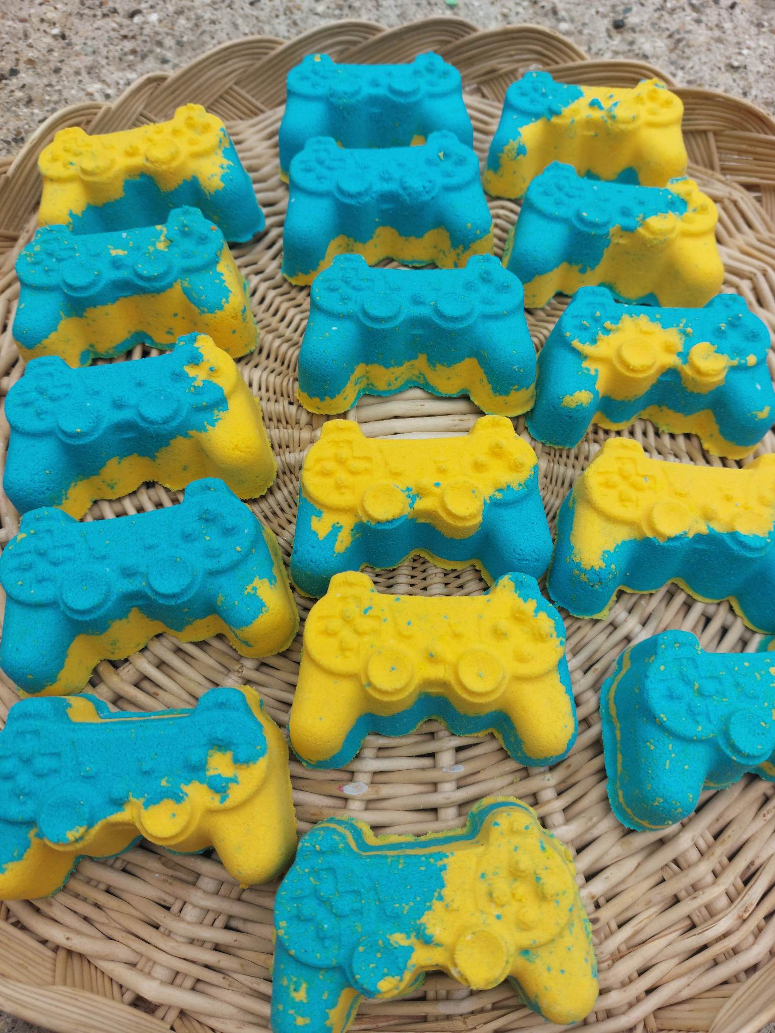 A collection of bath bombs shaped like gaming controllers, primarily in blue and yellow colors by BubbleShop